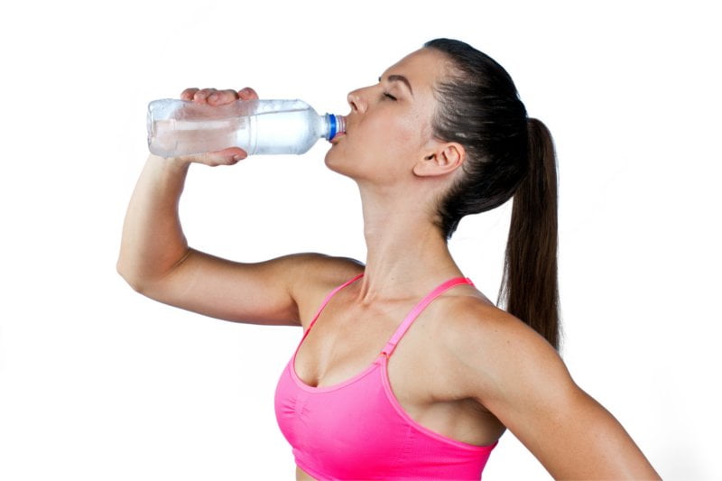 attractive fit woman drinking water from bottle after exercise